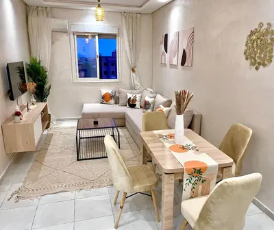 a living room with a table and a couch at Cosy appartement near to airport in Marrakech