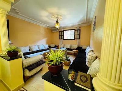 a living room with couches and potted plants at Cozy room in marrakech in Marrakech