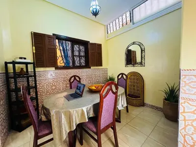 a dining room with a table with a laptop on it at Cozy room in marrakech in Marrakech