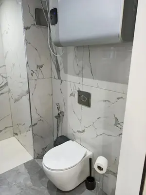 a white toilet in a bathroom with marble walls at Splendid One Bedroom center of Marrakech -Gueliz- in Marrakech