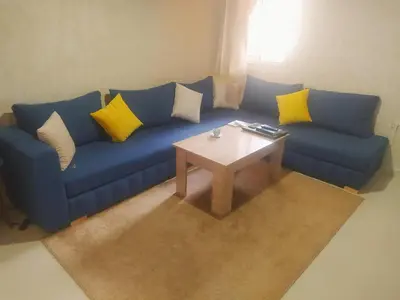 a living room with a blue couch and a table at Apartment Targa Reserved for Families in Marrakech