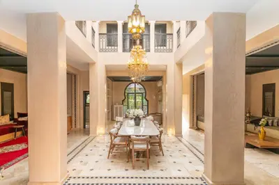 a dining room with a table and a chandelier at Villa riad raffinée privée à Marrakech in Marrakech