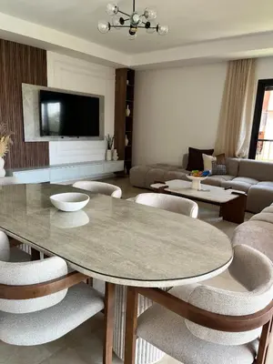 a living room with a table and chairs at Élégance et confort 3 chambre sur le golf de Noria in Marrakech