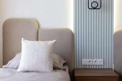 a bed with a white pillow next to a wall at Élégance et confort 3 chambre sur le golf de Noria in Marrakech