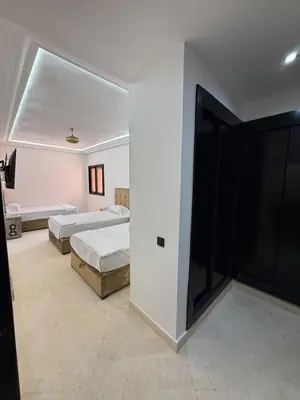 a bedroom with two beds and a large sliding door at BIG comfort with pool North Gueliz RIAD Ambiance in Marrakech
