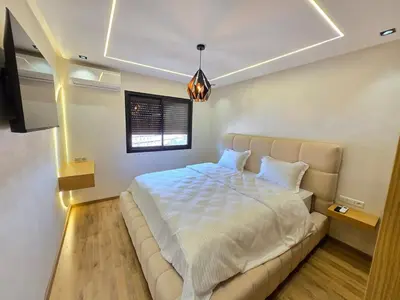 a bedroom with a large bed and a couch at Appartement avec piscine in Marrakech