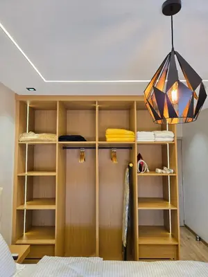 a closet with wooden shelves and a chandelier at Appartement avec piscine in Marrakech