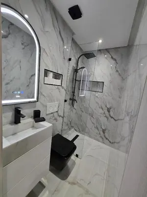 a bathroom with a shower and a sink and a mirror at Appartement avec piscine in Marrakech