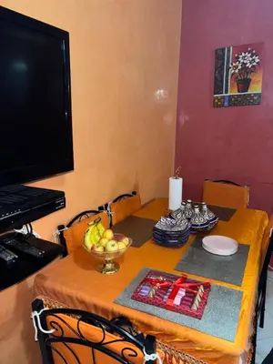 a table with a bowl of fruit and a television at 2 bedroom apartment with Moroccan living room in Allal El Fassi in Marrakech
