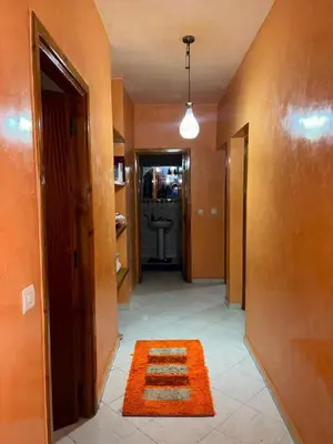 a hallway with an orange rug and a bathroom at 2 bedroom apartment with Moroccan living room in Allal El Fassi in Marrakech