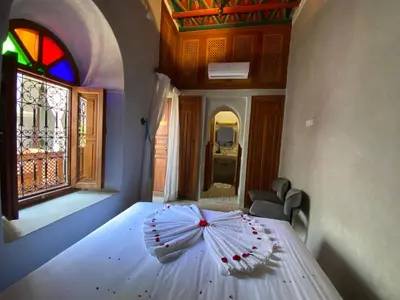 a bedroom with a white bed with an umbrella on it at Riad Bab Yacout & SPA in Marrakech