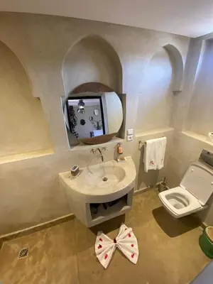 a bathroom with a sink and a toilet and a mirror at Riad Bab Yacout & SPA in Marrakech