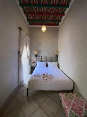 a bedroom with a white bed with a decorated ceiling at Riad Bab Yacout & SPA in Marrakech