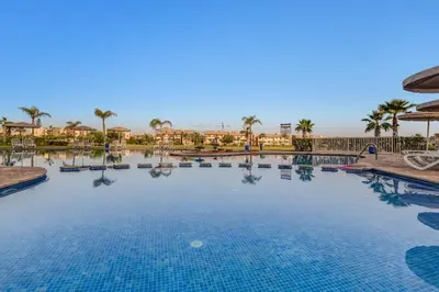 a large swimming pool at a resort with palm trees at Nice apartment in Marrakesh in Marrakech