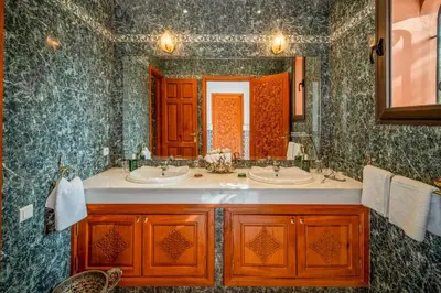 a bathroom with two sinks and a large mirror at Taj Palmeraie Palace Marrakech in Marrakech