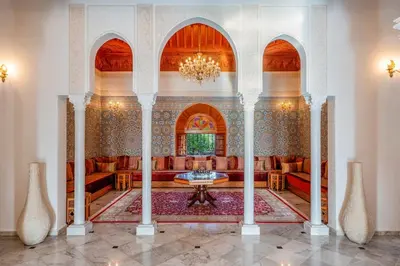 a living room with a chandelier and a table at Taj Palmeraie Palace Marrakech in Marrakech