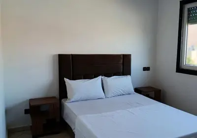 a bedroom with a bed with white sheets and pillows at Séjour Arty et Confort à Marrakech in Marrakech