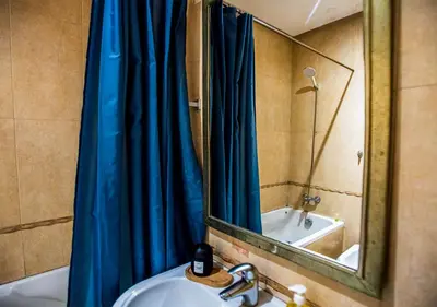 a bathroom with a blue shower curtain and a sink at Séjour Arty et Confort à Marrakech in Marrakech