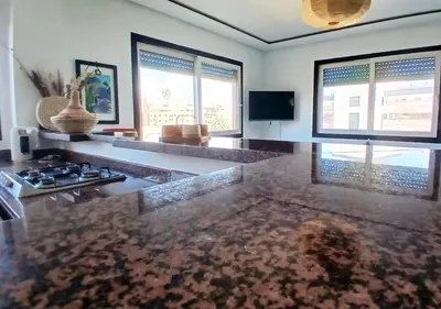 a living room with a counter top and two windows at Séjour Arty et Confort à Marrakech in Marrakech
