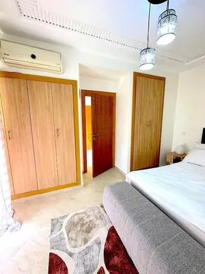 a bedroom with a large bed and wooden cabinets at Pause rêvée au cœur de Marrakech in Marrakech