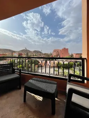 a balcony with two benches and a view of a city at Appartement Centre Ville Gueliz Parking Inclus in Marrakech