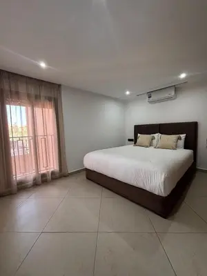 a bedroom with a large bed and a window at Elegant Duplex 2 chambres in Marrakech