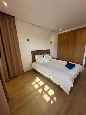 a bedroom with a large bed with white sheets at Villa familiale a 10km du boulevard Mohamed VI in Marrakech