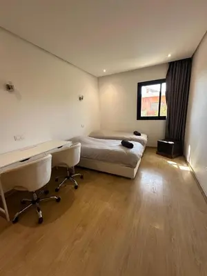 a bedroom with a bed and a desk and a desk at Villa familiale a 10km du boulevard Mohamed VI in Marrakech