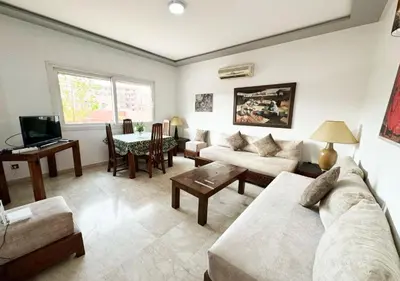 a living room with a couch and a table at Escapade citadine avec balcon et confort total in Marrakech
