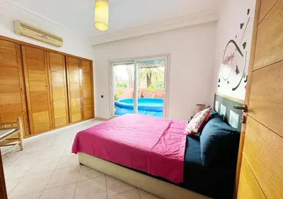 a bedroom with a large bed and a window at Escapade citadine avec balcon et confort total in Marrakech