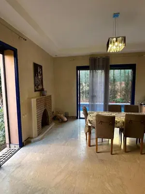 a living room with a table and a fireplace at Villa Marrakech haut standing avec piscine et architecture arabesque in Marrakech