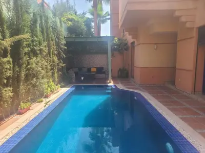 a swimming pool in the backyard of a house at Villa Marrakech haut standing avec piscine et architecture arabesque in Marrakech