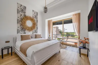 a bedroom with a large bed and a large window at M REVASION villa 5 chambres front de golf Petit déjeuner petit ménage et Tranfert aéroport inclus in Marrakech