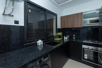 a black kitchen with a sink and a dishwasher at Elegance and Comfort in Marrakesh in Marrakech