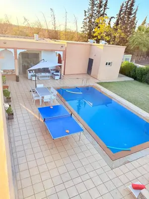 a swimming pool on a patio with a table and chairs at Villa privée in Marrakech