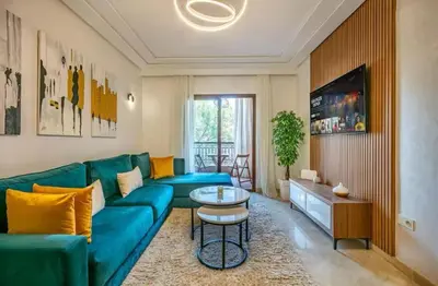 a living room with a blue couch and a table at Charme Central Appart Gueliz en Face La gare in Marrakech
