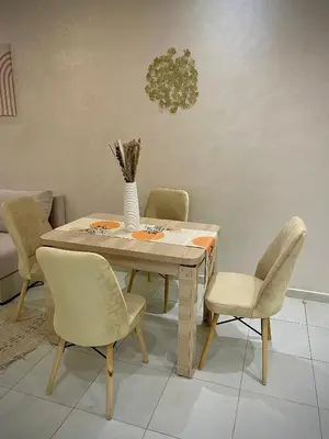 a dining room table with chairs and a vase on it at Appartement cosy 2 min aéroport Marrakech 2 chambres bien équipé in Marrakech