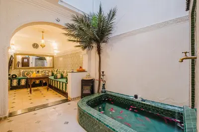 a swimming pool in a room with a palm tree at Riad - Jacuzzi & Breakfast , 5min walk Jemaa El Fnaa & Vue Rooftop Médina in Marrakech