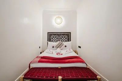 a bedroom with a bed with a red and white blanket at Riad - Jacuzzi & Breakfast , 5min walk Jemaa El Fnaa & Vue Rooftop Médina in Marrakech