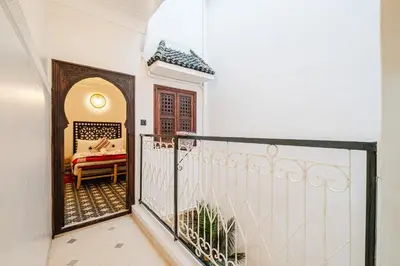 a balcony with a gate and a bed in a room at Riad - Jacuzzi & Breakfast , 5min walk Jemaa El Fnaa & Vue Rooftop Médina in Marrakech