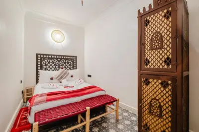 a bedroom with a bed with a red blanket at Riad - Jacuzzi & Breakfast , 5min walk Jemaa El Fnaa & Vue Rooftop Médina in Marrakech