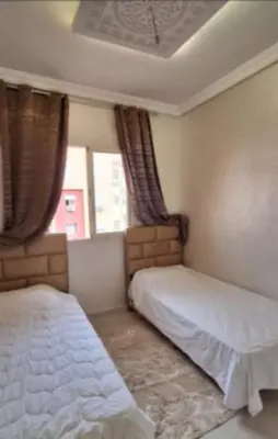a bedroom with two beds and two windows at Marrake Appartement familiale au centre de in Marrakech