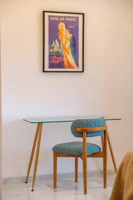 a table and a chair and a picture on the wall at Modern and Cozy Apartment Center of Marrakech in Marrakech
