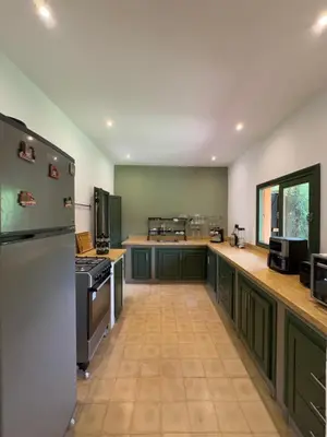 a large kitchen with green cabinets and appliances at Villa Atlas Chill in Marrakech