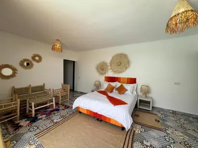 a bedroom with a bed and a table and chairs at Villa familiale, piscine privée sans vis-à-vis in Marrakech