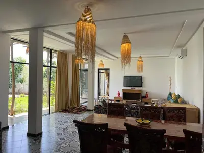 a living room with a table and a couch at Villa familiale, piscine privée sans vis-à-vis in Marrakech