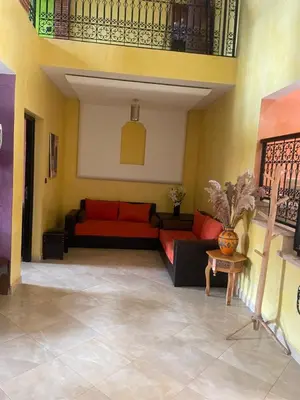 a living room with a red couch and a table at Duplex Village in Marrakech
