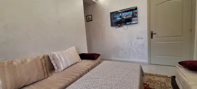 a living room with a couch and a tv on the wall at Appartement avec bel vue au centre de Marrakech in Marrakech