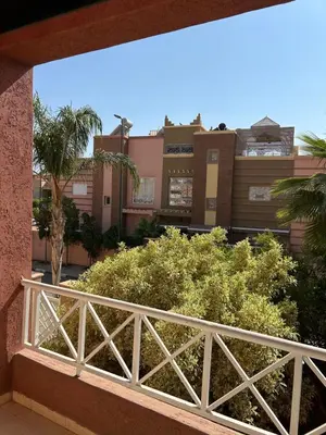 a balcony with a white fence and trees and buildings at Villa moderne avec jacuzzi & jardin - Marrakech in Marrakech