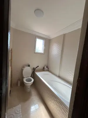 a bathroom with a bath tub and a toilet at Villa moderne avec jacuzzi & jardin - Marrakech in Marrakech